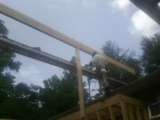 Carpenter setting a ridge beam over a new addition frame — Ice Dam Removal by Roofing Brothers in Long Valley