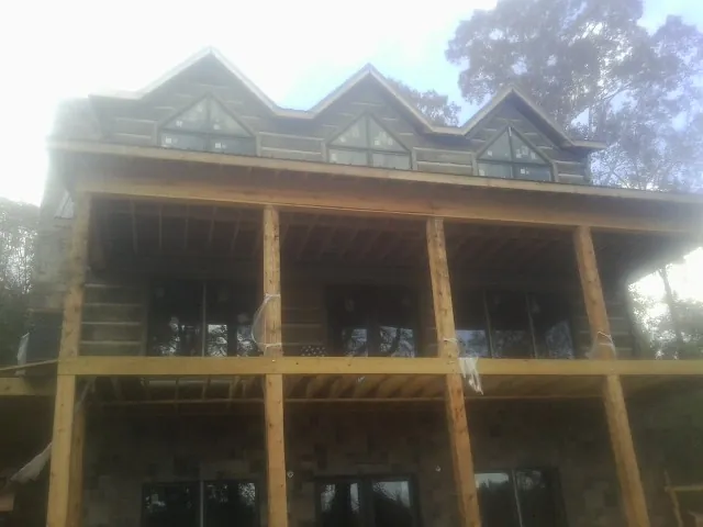 Dormers and porch framing on a large log home under construction — Roof Coating work by our crew in Long Valley