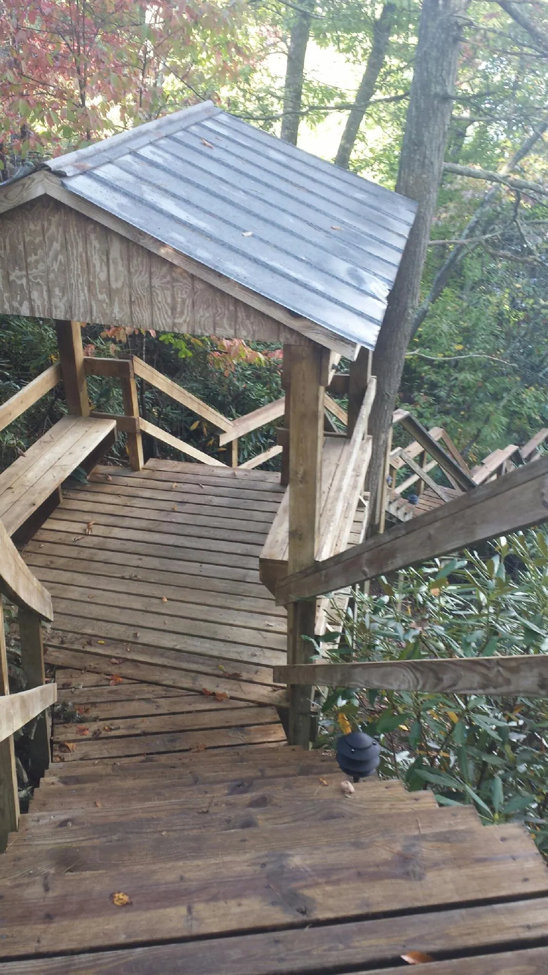 Metal roofed shelter over wooden steps on a wooded walkway — Skylight Repair & Installation work by our crew in Long Valley