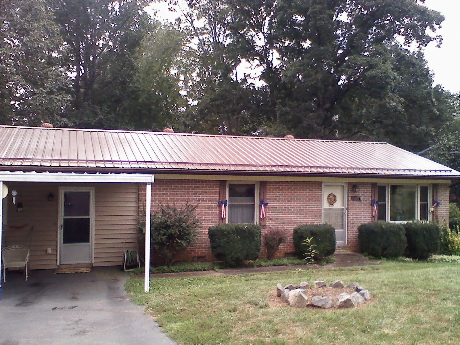 Bronze metal roof and carport on a brick ranch home — Roof Repair work by our crew in Long Valley