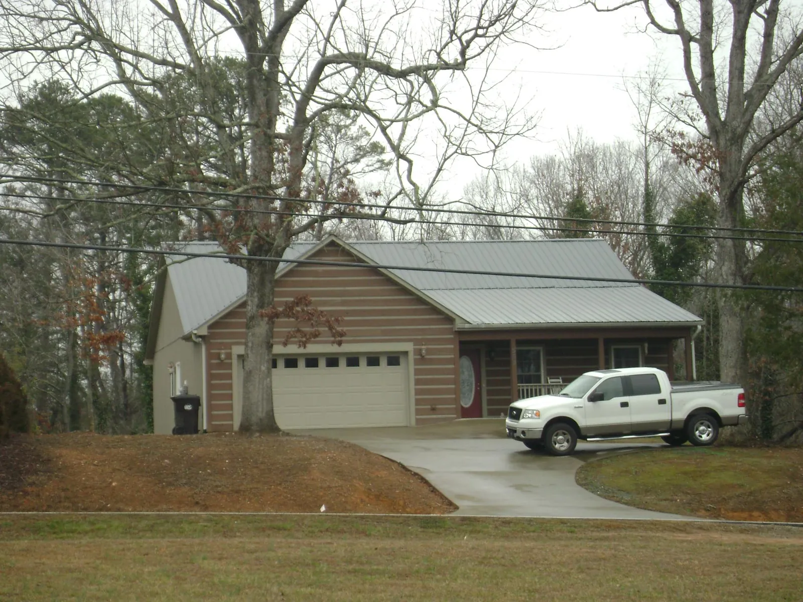Gray metal roof on a log sided house with an attached two car garage in Long Valley